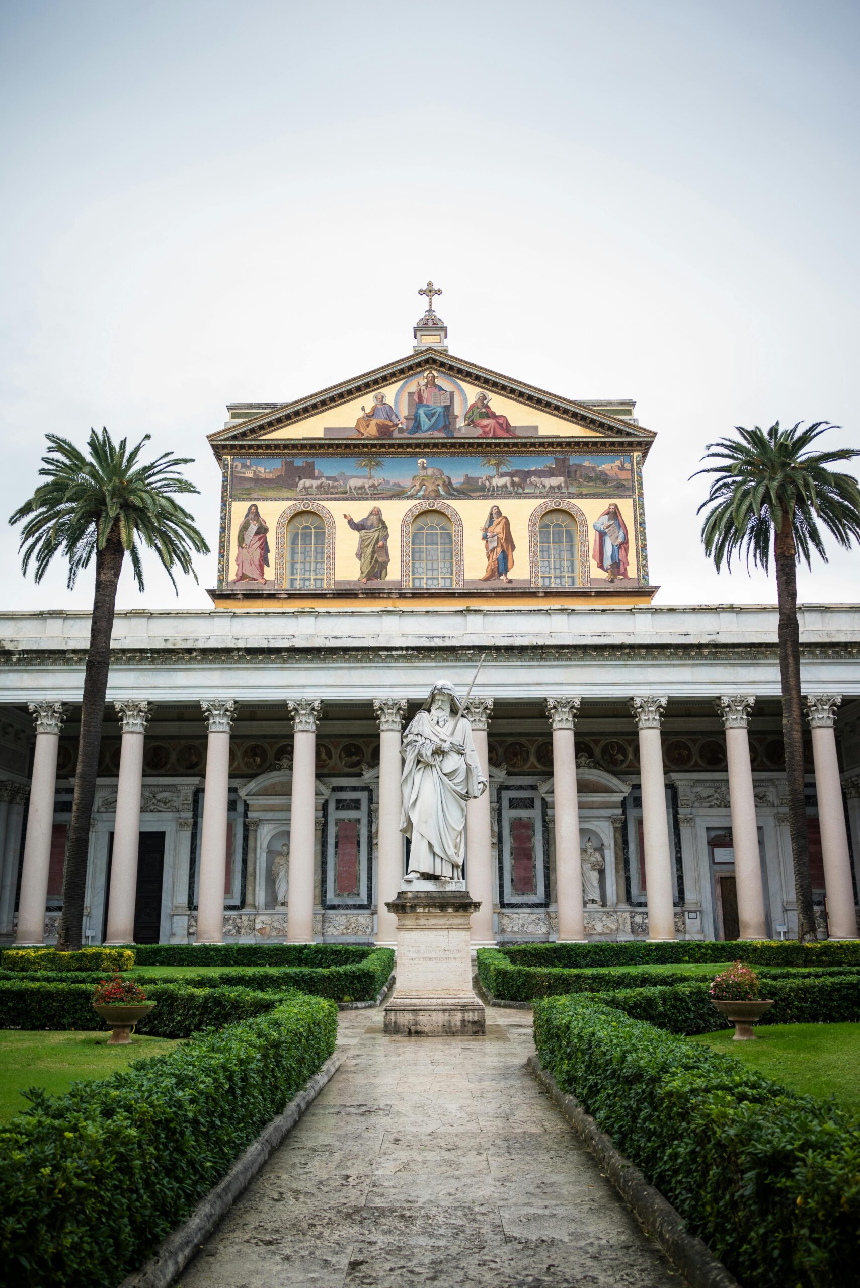 Fachada da Basílica de São Paulo Extramuros com o pátio e a estátua de São Paulo.