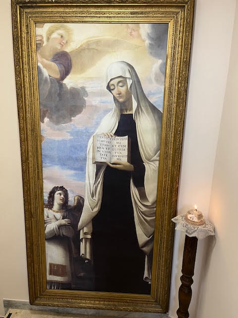 Quadro de Santa Francisca Romana na igreja que leva seu nome, em Roma, segurando um livro com o dizer de glorificar a Deus com tudo o que ela tem, ao lado de seu anjo da guarda.