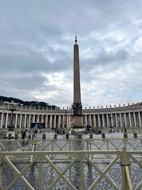 Obelisco de granito no centro da Praça de São Pedro, símbolo que presenciou o martírio de São Pedro no antigo Circo de Nero e hoje traz uma cruz no topo.