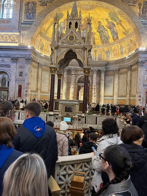 Multidão reunida diante do baldaquino do altar maior da Basílica de São Paulo Extramuros durante o Jubileu 2025, com a entrada para o túmulo do apóstolo visível ao centro.