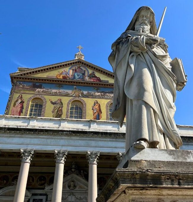 Fachada da Basílica de São Paulo Extramuros em Roma, com jardim e estátua do apóstolo