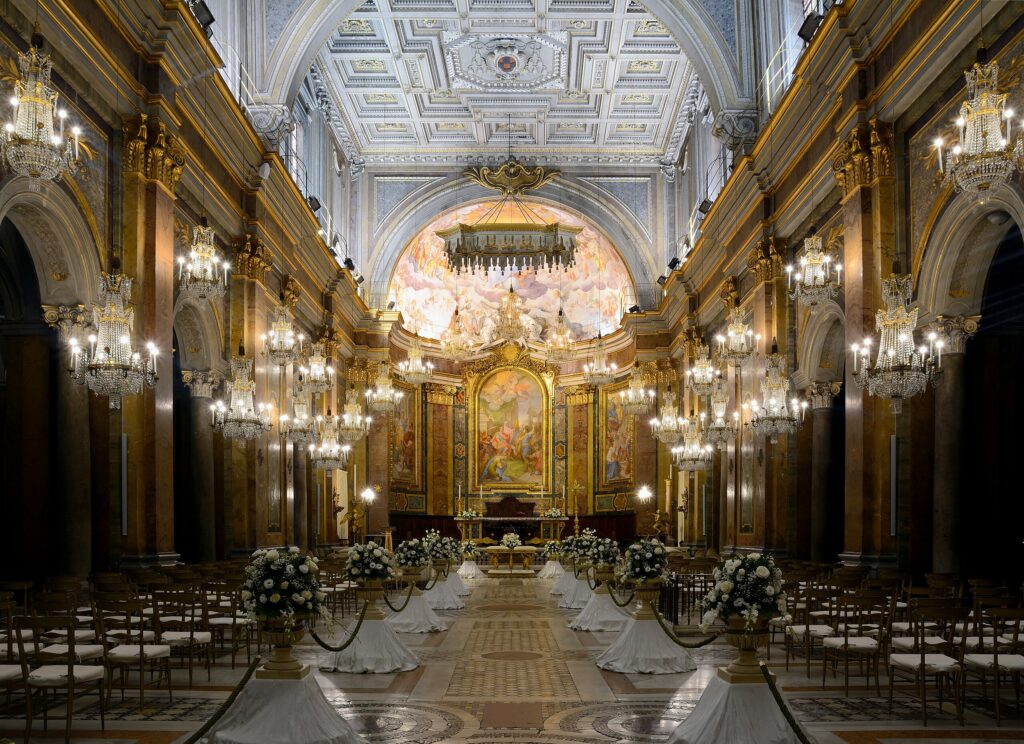 Interior da Basílica dos Santos João e Paulo em Roma, com o altar principal e decoração barroca, onde repousam os mártires e São Paulo da Cruz.