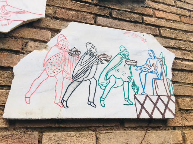 Pintura representando os Reis Magos oferecendo presentes ao Menino Jesus nos braços da Virgem Maria, em uma parede externa das Catacumbas de São Calixto em Roma.