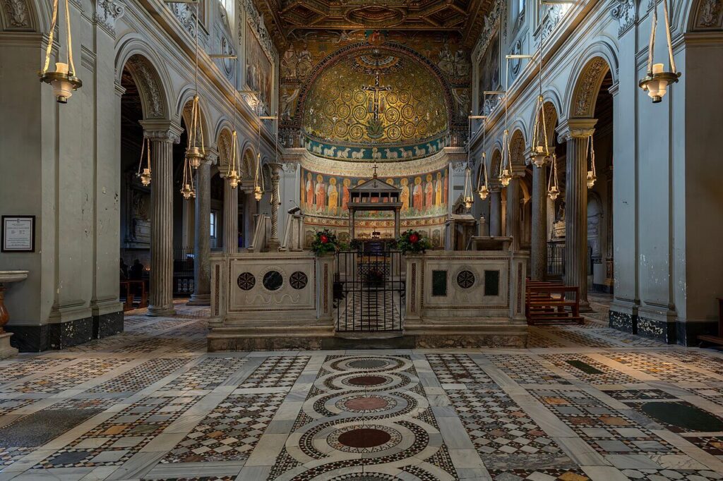 Interior da Basílica de São Clemente, em Roma — destaque para o piso cosmatesco e o mosaico da abside medieval.