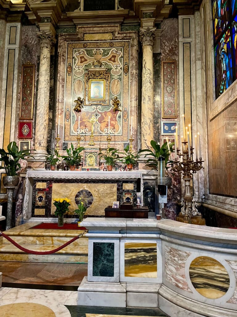 Capela da Madonna del Pozzo em Santa Maria in Via, com o altar da imagem miraculosa e o poço histórico de onde é retirada a água considerada milagrosa